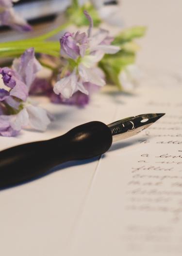 Foto, Blumen mit Füller und beschriebenem Papier