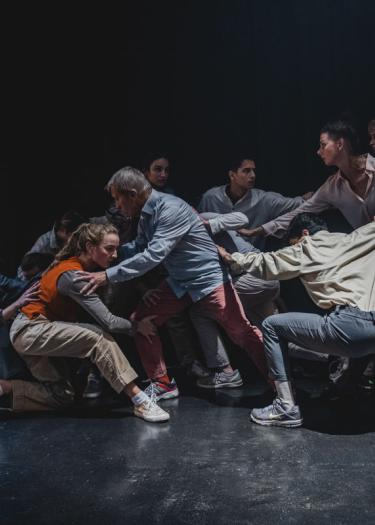 Foto, Gruppe von Tänzern vor dunklem Hintergrund
