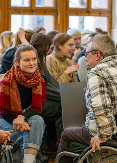 Studierende im Gespräch mit Rollstuhlfahrer