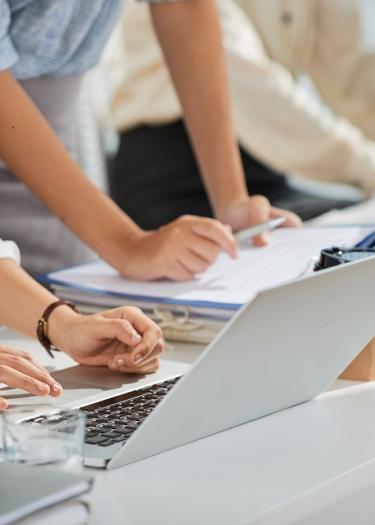 Menschen, die an einem Schreibtisch an Laptops arbeiten
